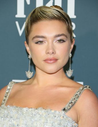 Florence Pugh wore a silver ensemble stylized with glittery floral drop earrings.