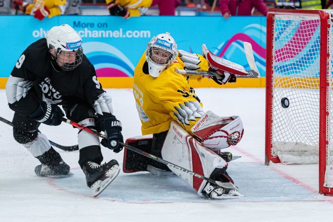 Slovakia's Adam Sýkora knocks in the puck against Switzerland goalie Loris Uberti during a their 3-on-3 Preliminary Round Games at the Lausanne 2020 Winter Youth Olympics on Sunday, January 12, in Switzerland.