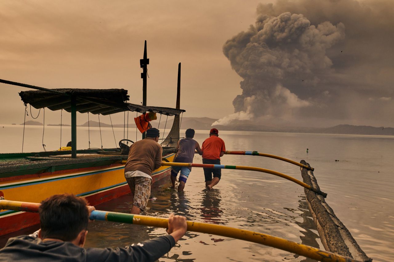 Residents prepare their boats to evacuate Talisay on January 13.