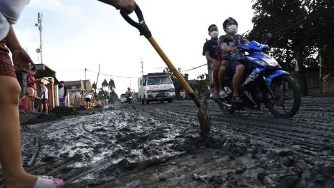A resident clears mud and ash in Tanauan town on January 13, 2020.