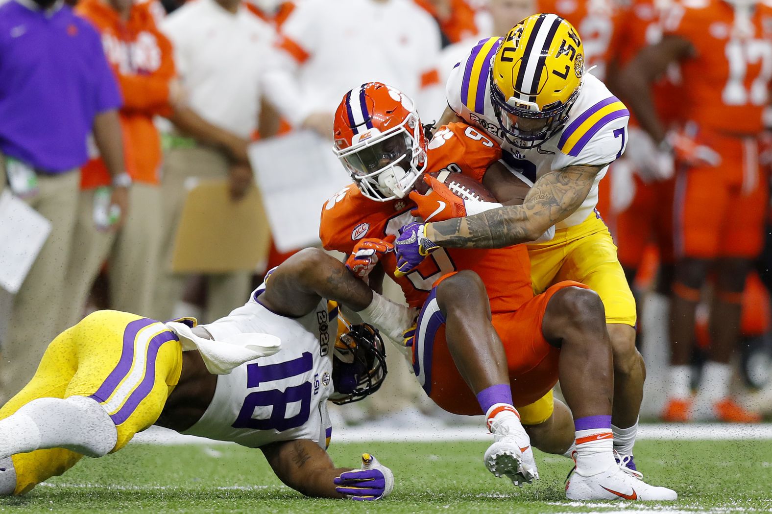 Etienne is tackled by Chaisson, left, and Delpit early in the game.