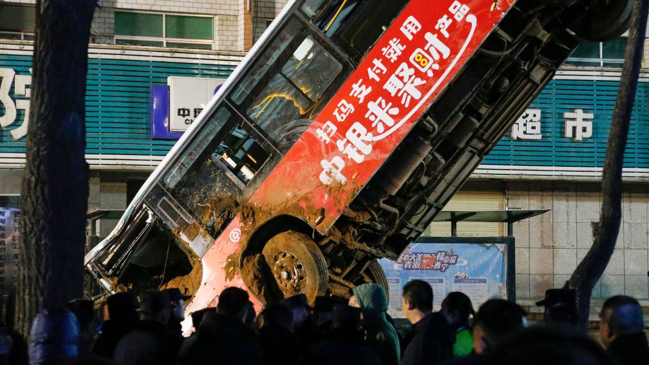 This photo taken on January 13, 2020 shows Chinese rescuers watching as a car is lifted out after a road collapse in Xining in China's northwestern Qinghai province. - An enormous sinkhole swallowed passers-by and a public bus in northwest China, reported state media on January 14, injuring fifteen people while another ten are still missing. (Photo by STR / AFP) / China OUT (Photo by STR/AFP via Getty Images)