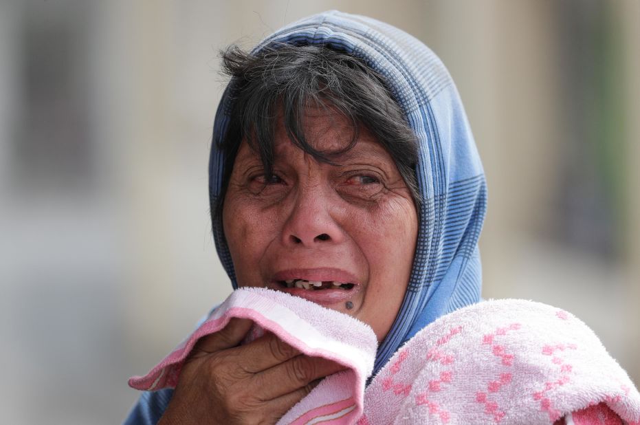 Erman Batan reacts over her missing husband, Roberto, whom she had not seen since they evacuated their home in Tagaytay on January 13.