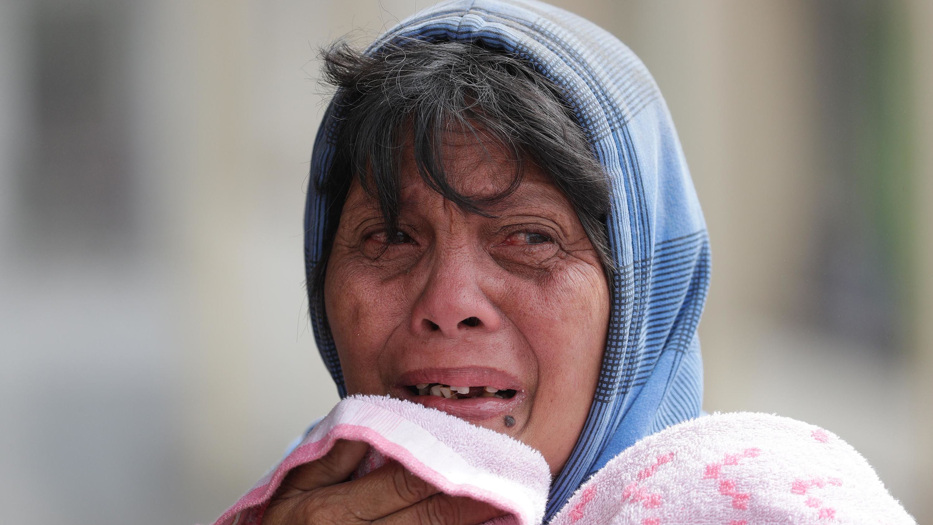 Erman Batan reacts over her missing husband, Roberto, whom she had not seen since they evacuated their home in Tagaytay on January 13.