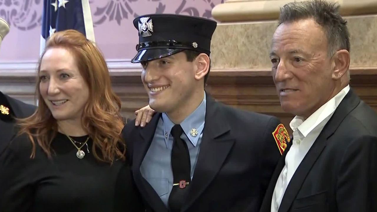 Bruce Springsteen and Patti Scialfa stand beside their son Sam, who was sworn in on Tuesday as a Jersey City firefighter.
