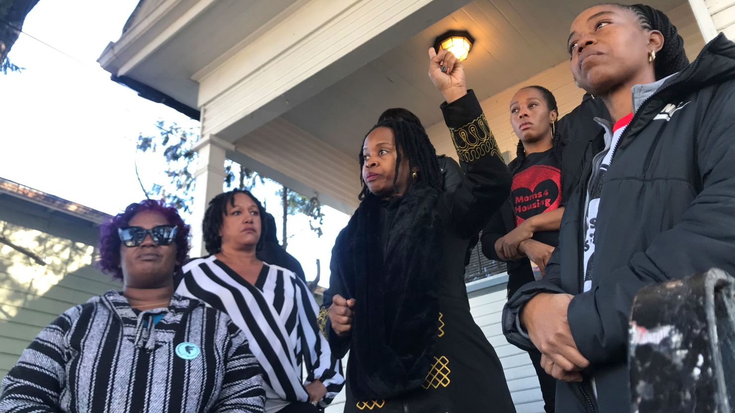 Sharena Thomas, left, Carroll Fife, center, Dominique Walker, second from right, and Tolani KIng, right, stand outside a vacant home they took over on Magnolia Street in West Oakland, Calif. 