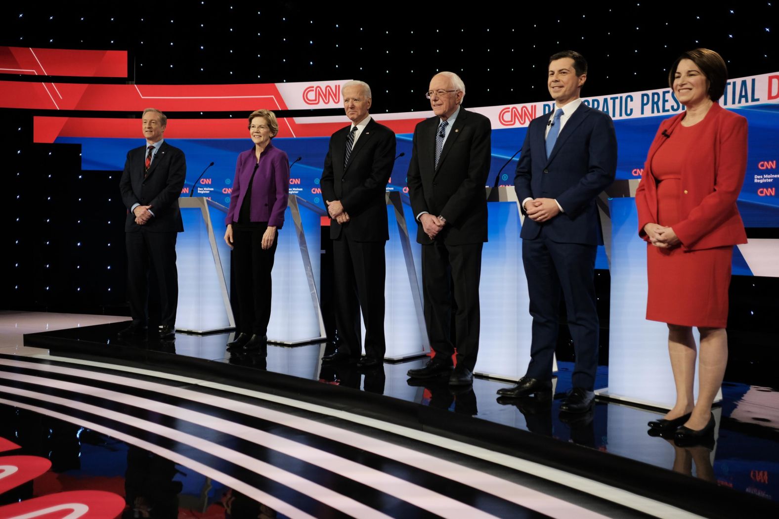 The candidates stand on stage before the start of the debate.