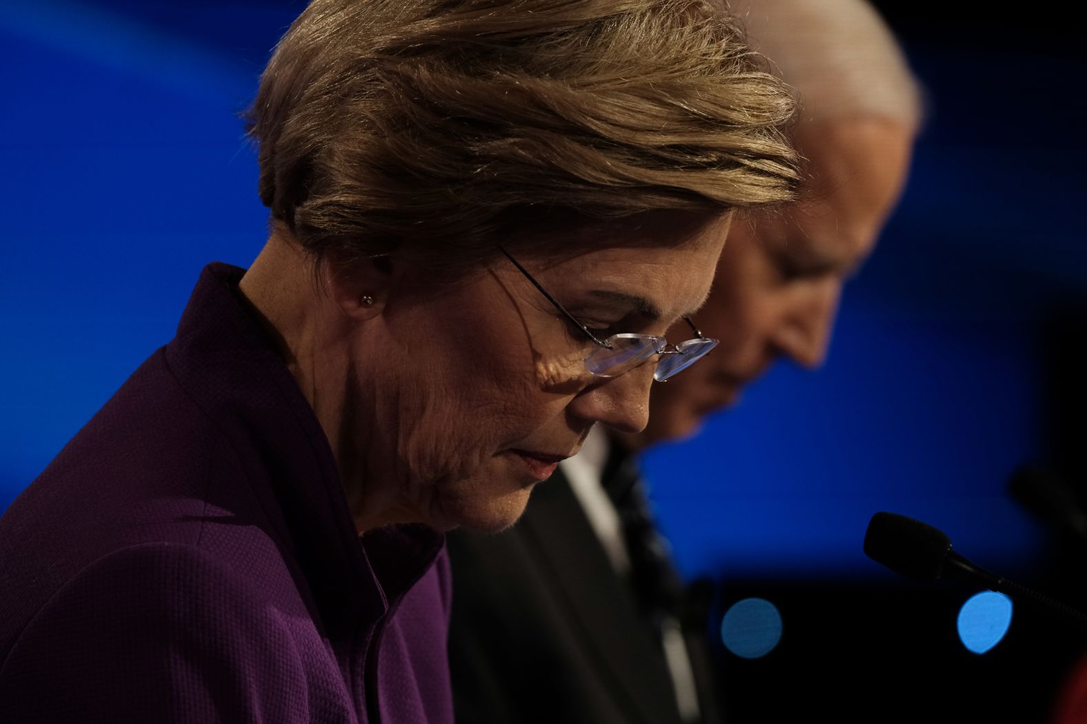 Warren and Biden look down at their notes during the debate.