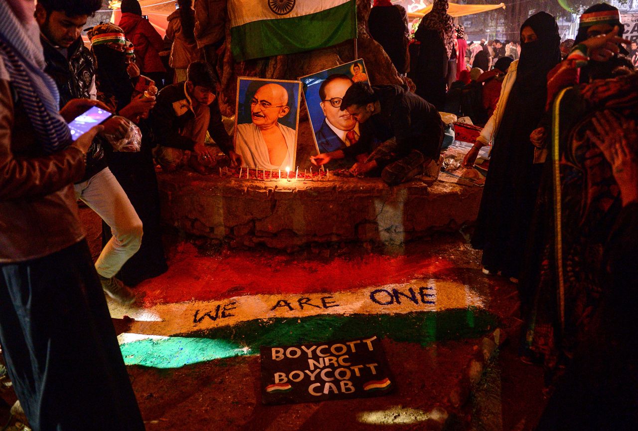 Protesters light candles near posters of Mahatma Gandhi and politician and social reformer Bhimrao Ramji Ambedkar during a demonstration against India's new citizenship law at Mansoor Ali Park in Allahabad on Tuesday, January 14.