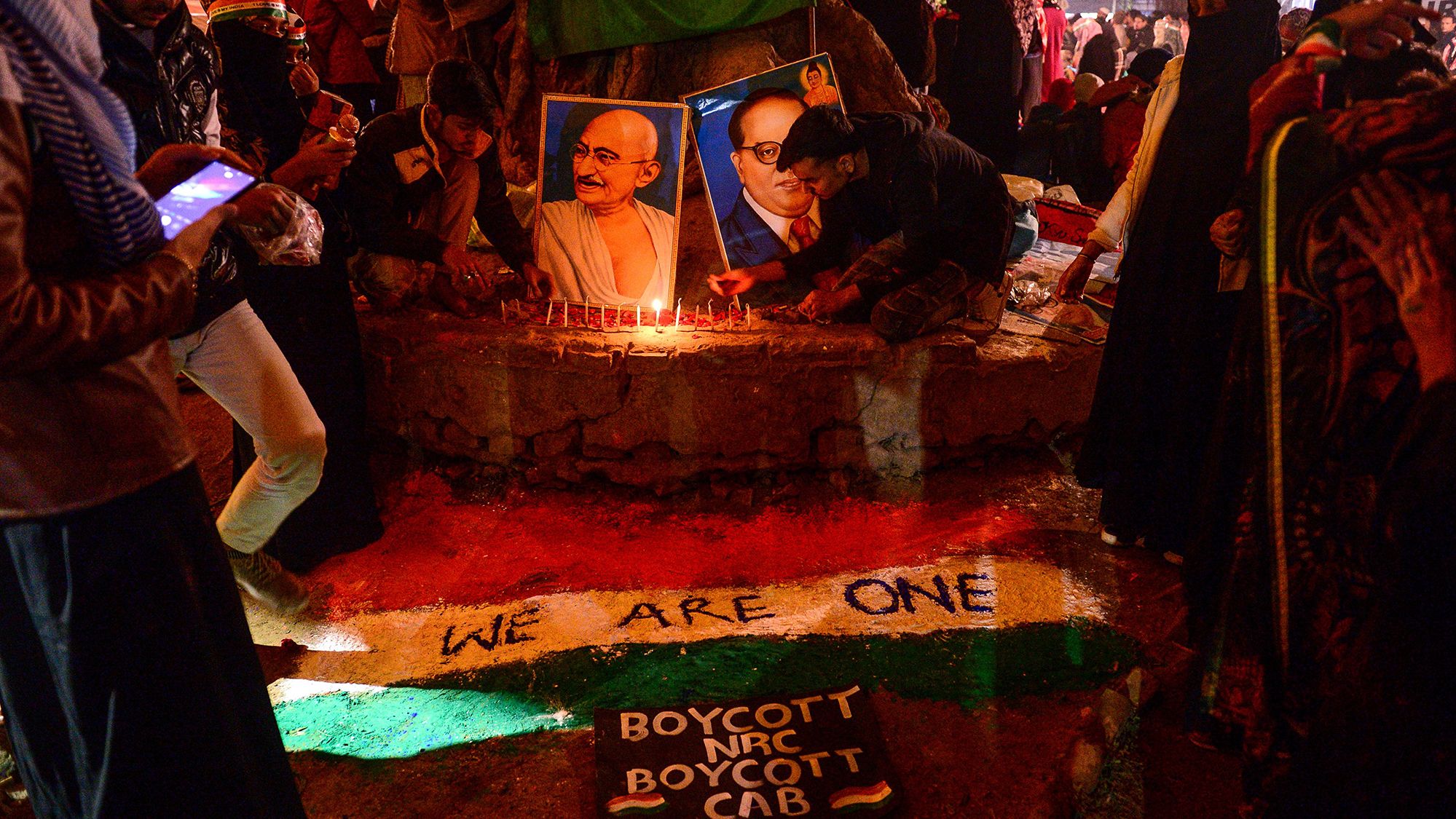 Protesters light candles near posters of Mahatma Gandhi and politician and social reformer Bhimrao Ramji Ambedkar during a demonstration against India's new citizenship law at Mansoor Ali Park in Allahabad on Tuesday, January 14. 