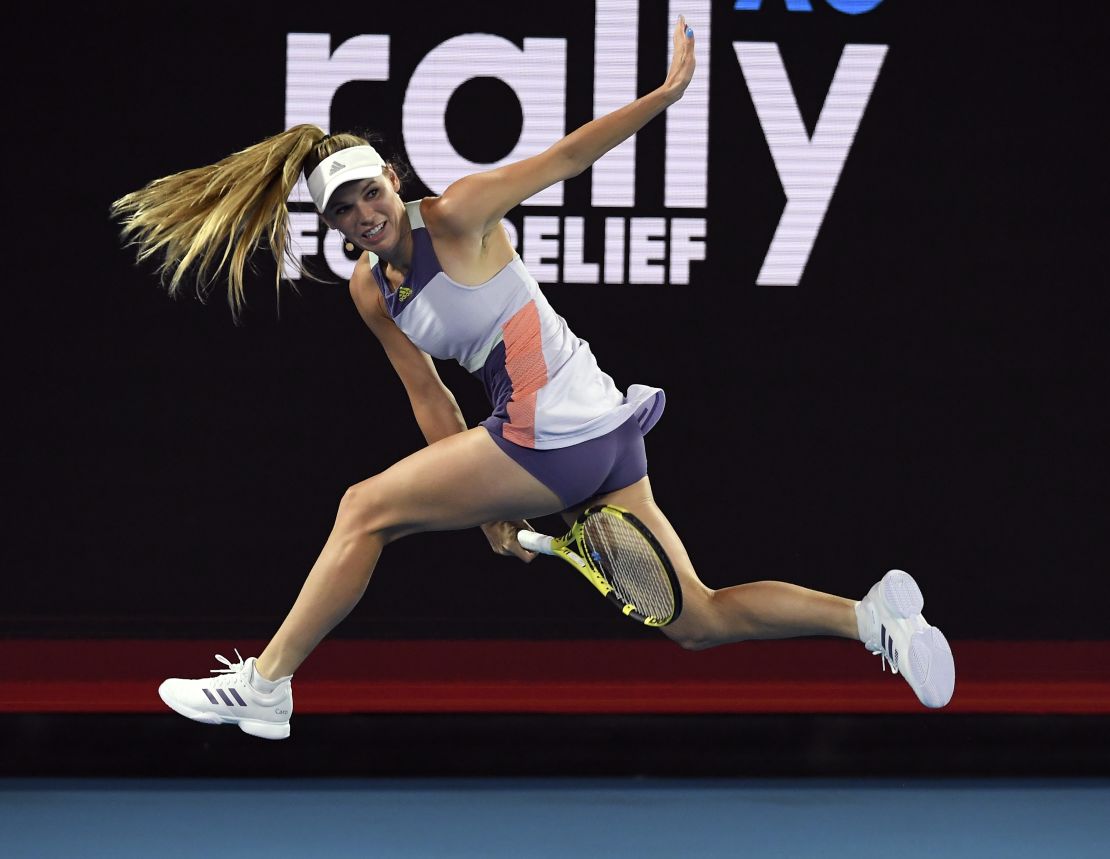 Caroline Wozniacki attempts a "tweener" (between the legs shot) during the Rally for Relief charity match in Melbourne
