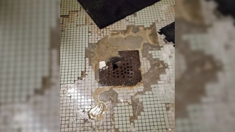 The inspector cited problems with showers, including leaks, missing knobs and this rusty drain.