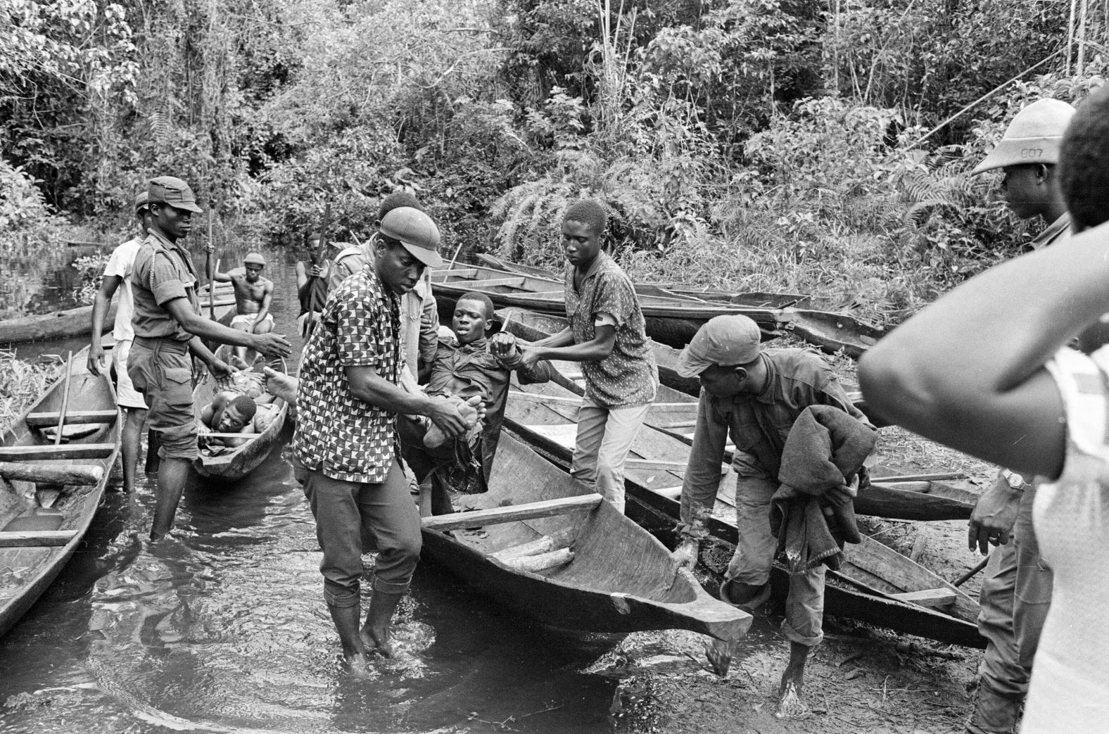 Wounded Biafran soldiers are transported across a river in June 1968.
