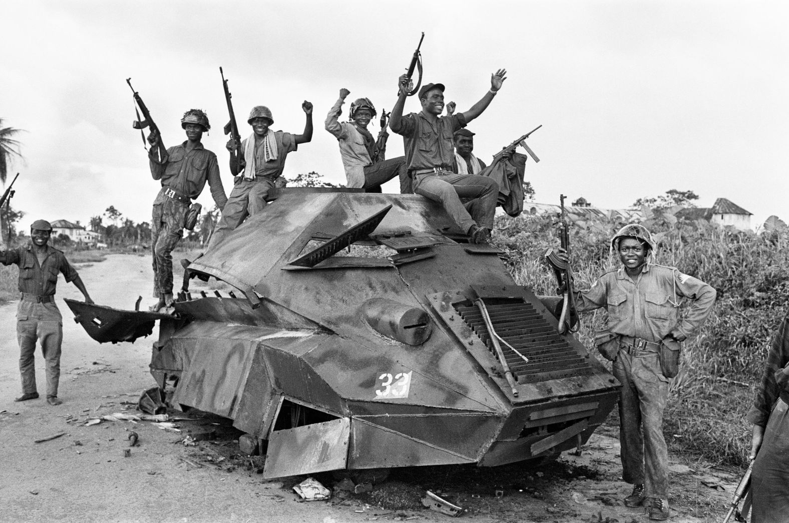 Jubilant Biafran soldiers celebrate on top of a destroyed Nigerian army armored personnel carrier.