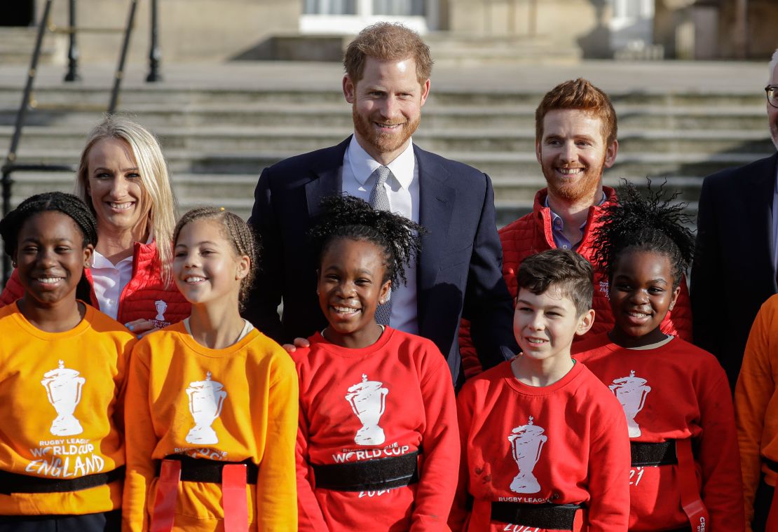 Prince Harry poses with schoolchildren and Rugby League World Cup 2021 ambassadors James Simpson, right, and Jody Cunningham in the gardens at Buckingham Palace.