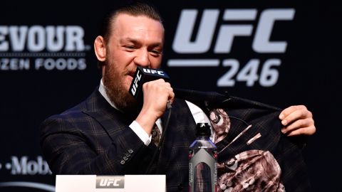 McGregor flashes the inside of his jacket during the UFC 246 press conference.