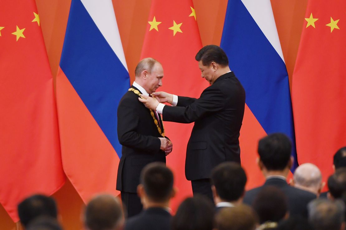 Chinese President Xi Jinping congratulates Russian President Vladimir Putin after presenting him with the Friendship Medal in the Great Hall of the People on June 8, 2018 in Beijing, China. 