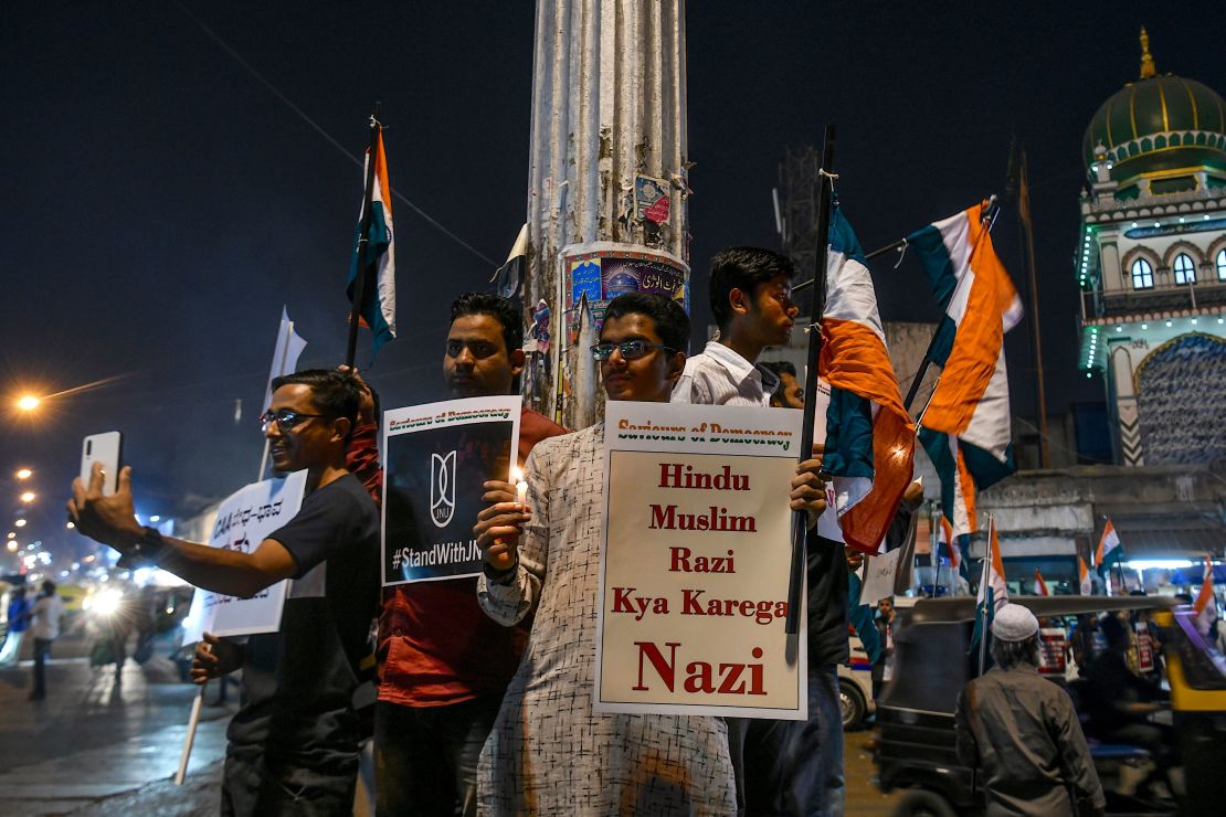 Protesters hold placards and national flags as they stage a candle light vigil condemning Indian Prime Minister Narendra Modi and India's new citizenship law, in Bangalore on January 14, 2020.