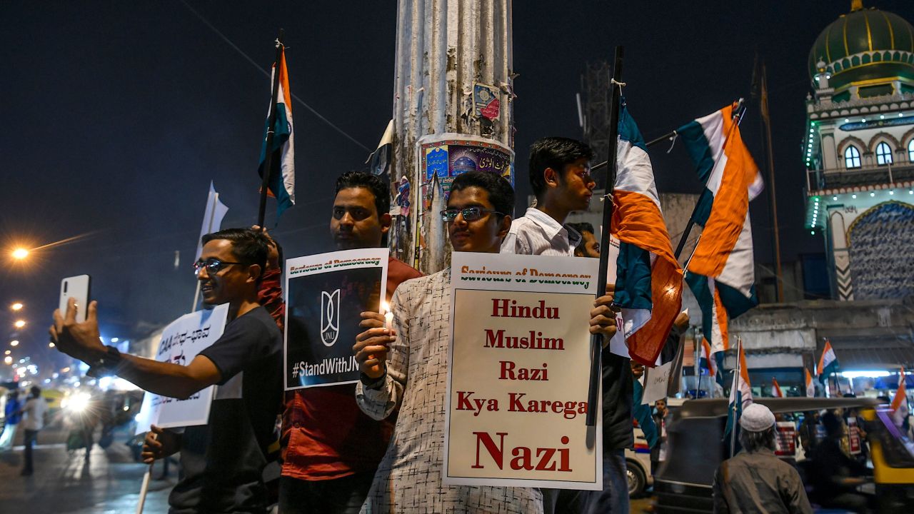 Protesters hold placards and national flags as they stage a candle light vigil condemning Indian Prime Minister Narendra Modi and India's new citizenship law, in Bangalore on January 14, 2020.