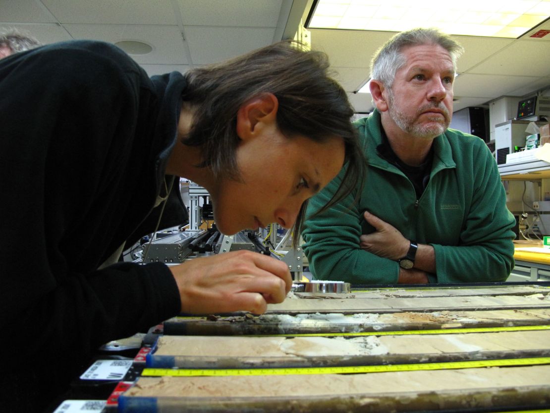 Researchers look at cores of rock drawn from the sea bed. 