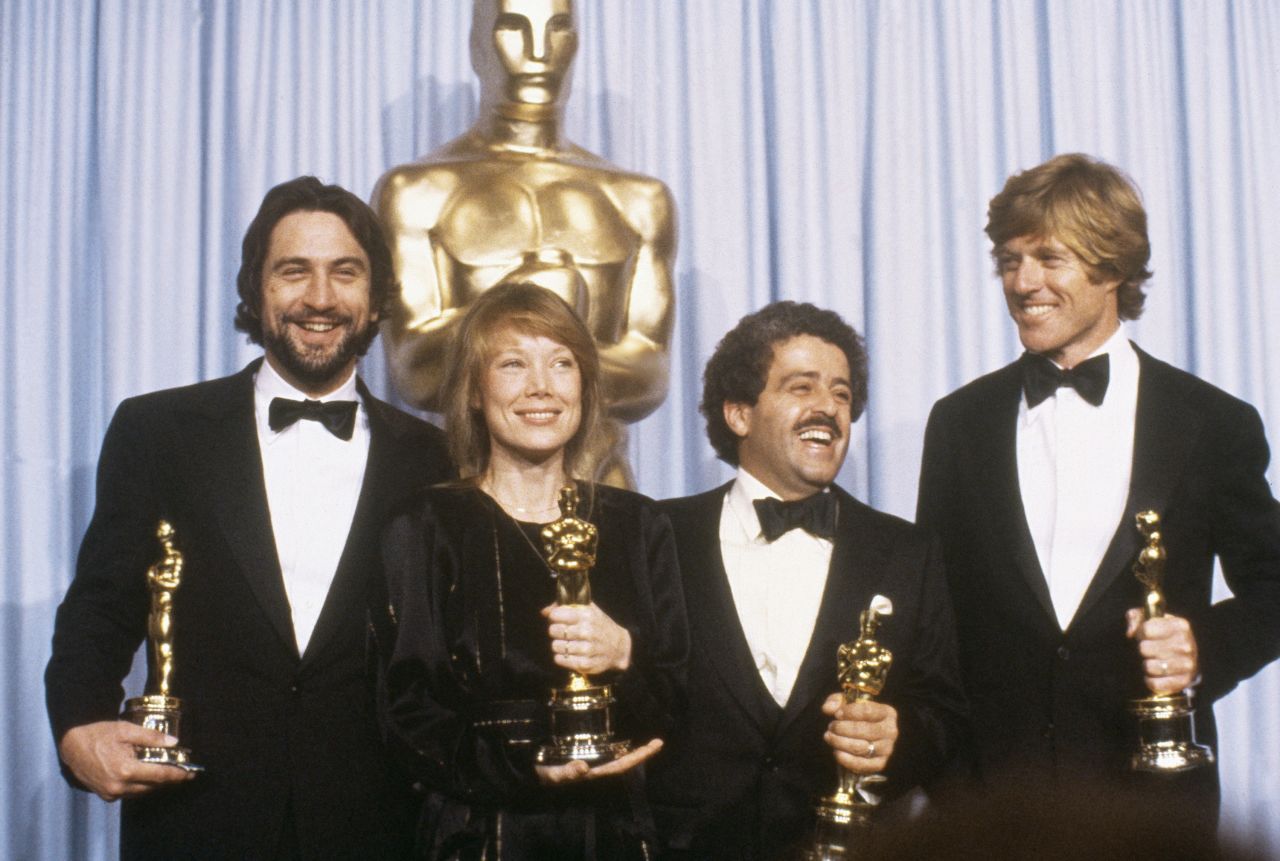 De Niro holds his best actor Oscar in 1981. With him, from left, are Sissy Spacek, Ronald L. Schwary and Robert Redford.