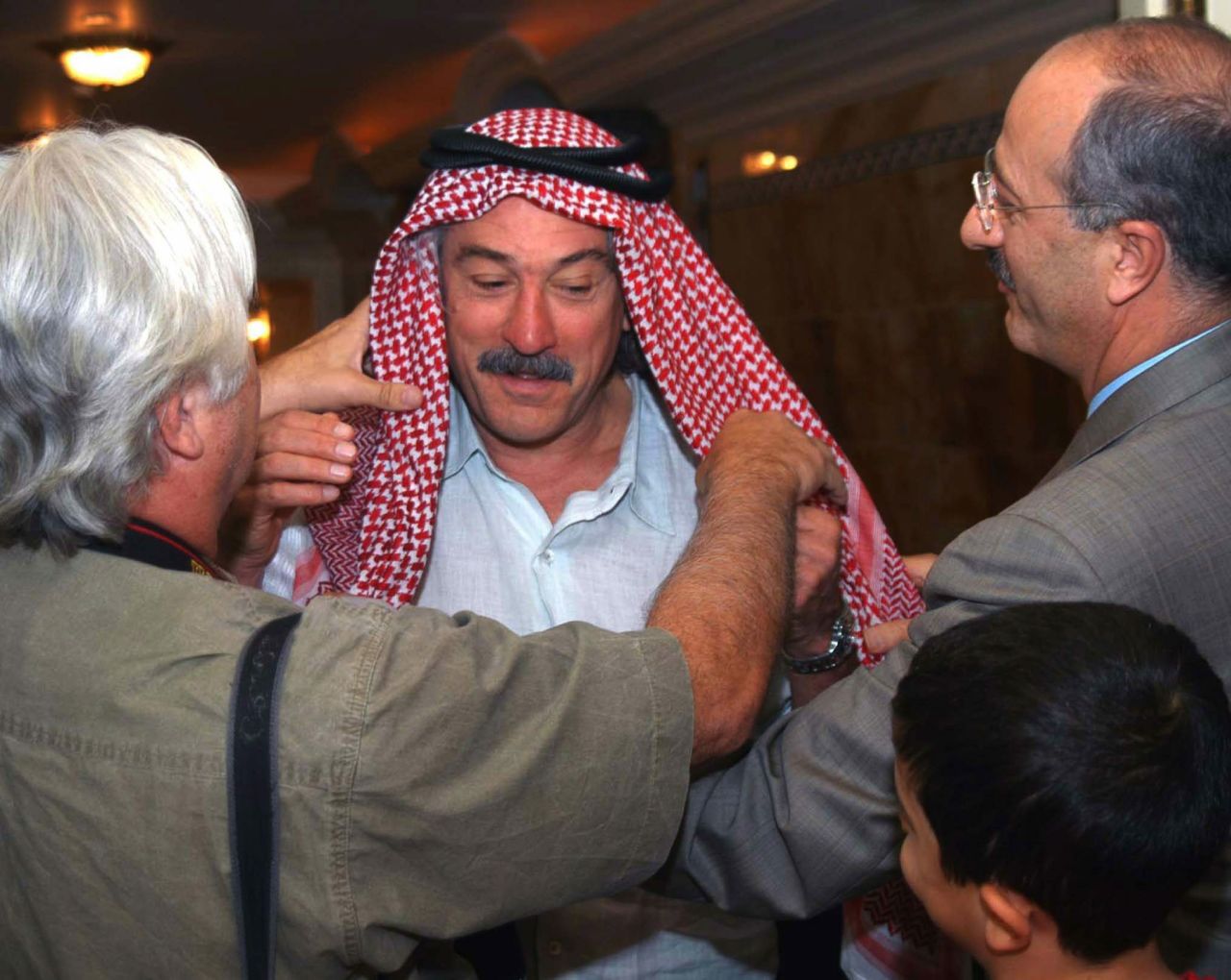 De Niro is fitted with traditional Kuwaiti dress during a US Army reception in 2003.