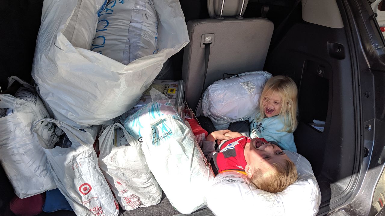 Tyler and his sister, Addison, with a trunk full of bedding donations.
