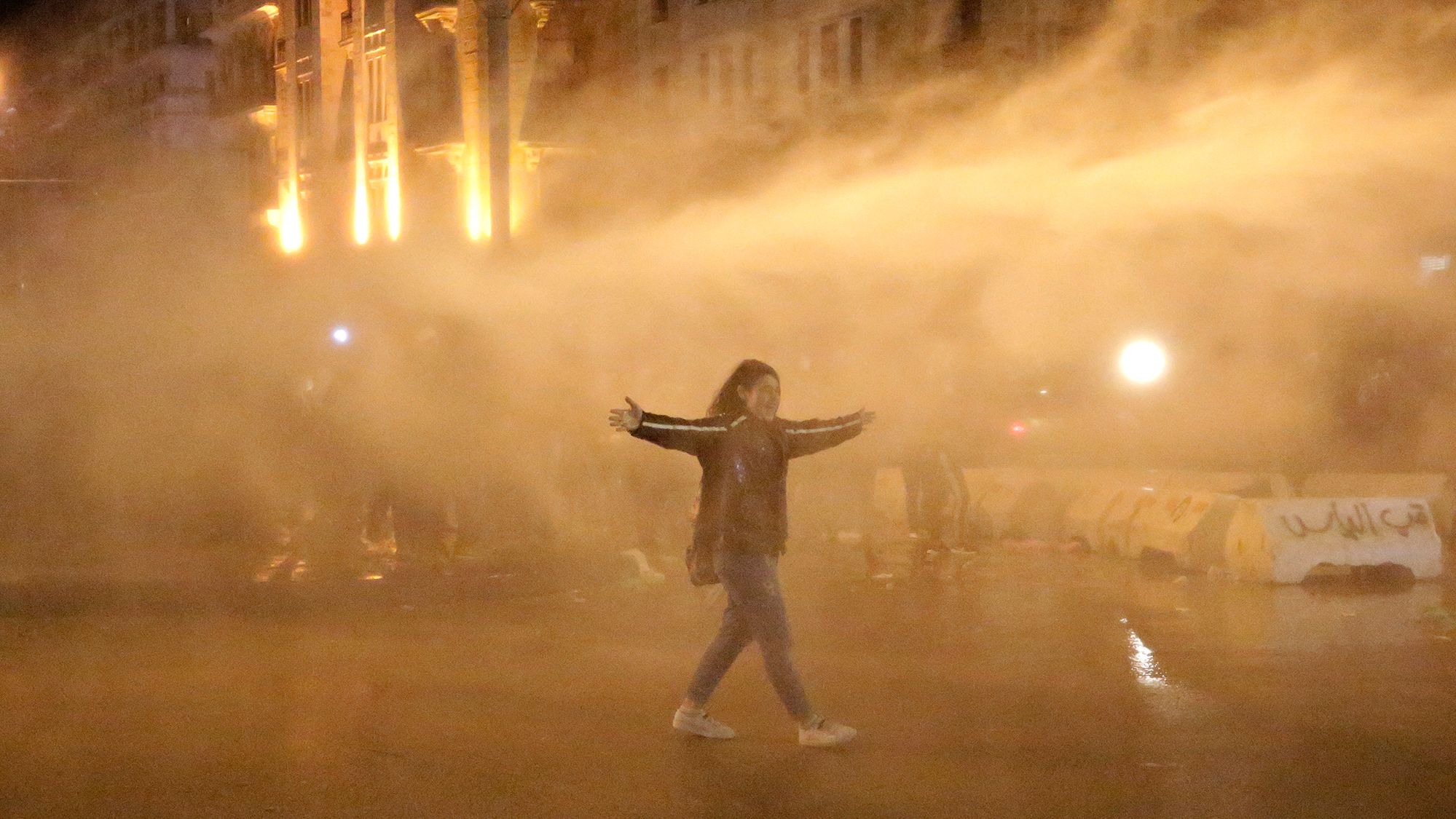 An anti-government protester is sprayed by a water canon during protests Sunday in Beirut.