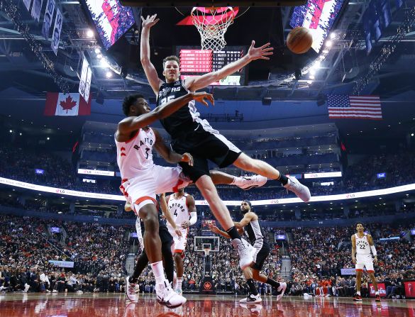 Toronto Raptors' OG Anunoby passes the ball against San Antonio Spurs' Jakob Poeltl during the first half of a game in Toronto, Canada, on Sunday, January 12. 