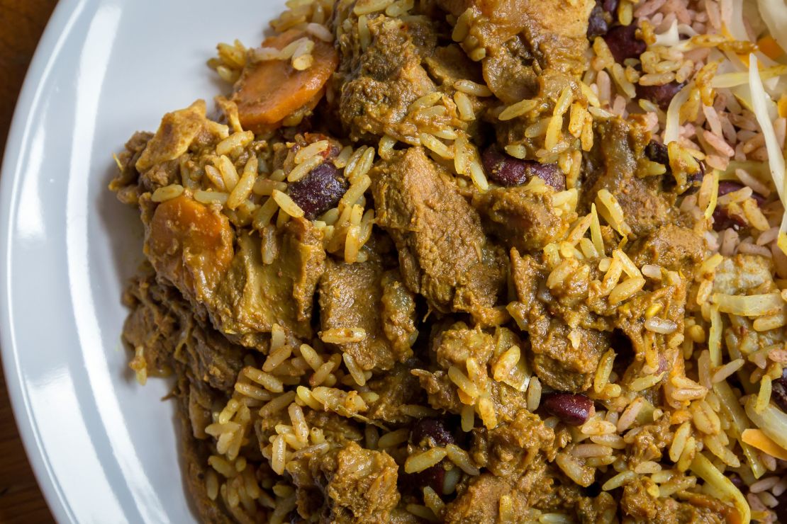 A plate of Jamaican curried goat, served with traditional rice and peas. 