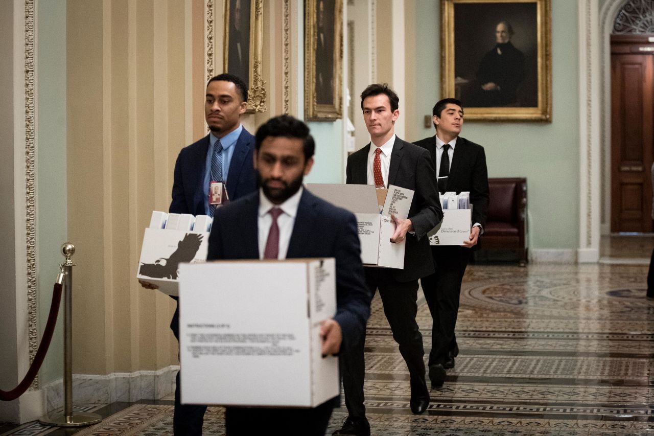 Staff members carry boxes of binders to Schumer's office on January 21.