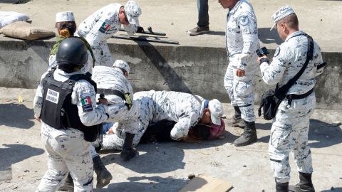 A Central American migrant is detained by a member of Mexico's National Guard after crossing the Suchiate River.