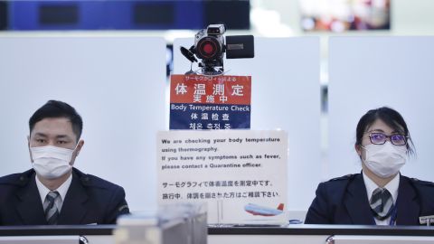 Japanese officers work at a health screening station as they observe passengers arriving on a flight from Wuhan, China.