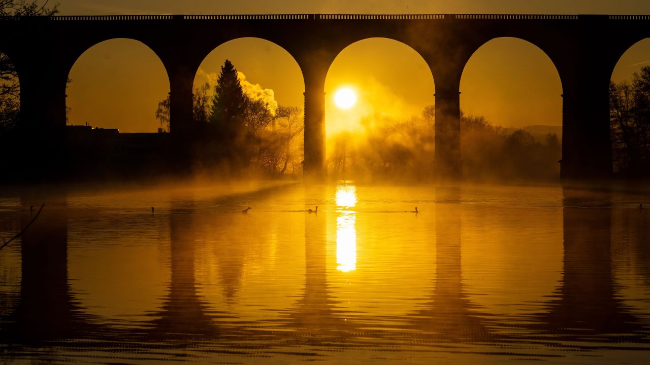 <strong>Herdecke, Germany: </strong>The sun rises behind the railway viaduct across the Ruhr valley in Northern Germany.