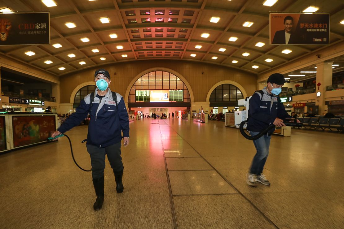 Staff members disinfect the Hankou Railway Station in Wuhan on Wednesday.