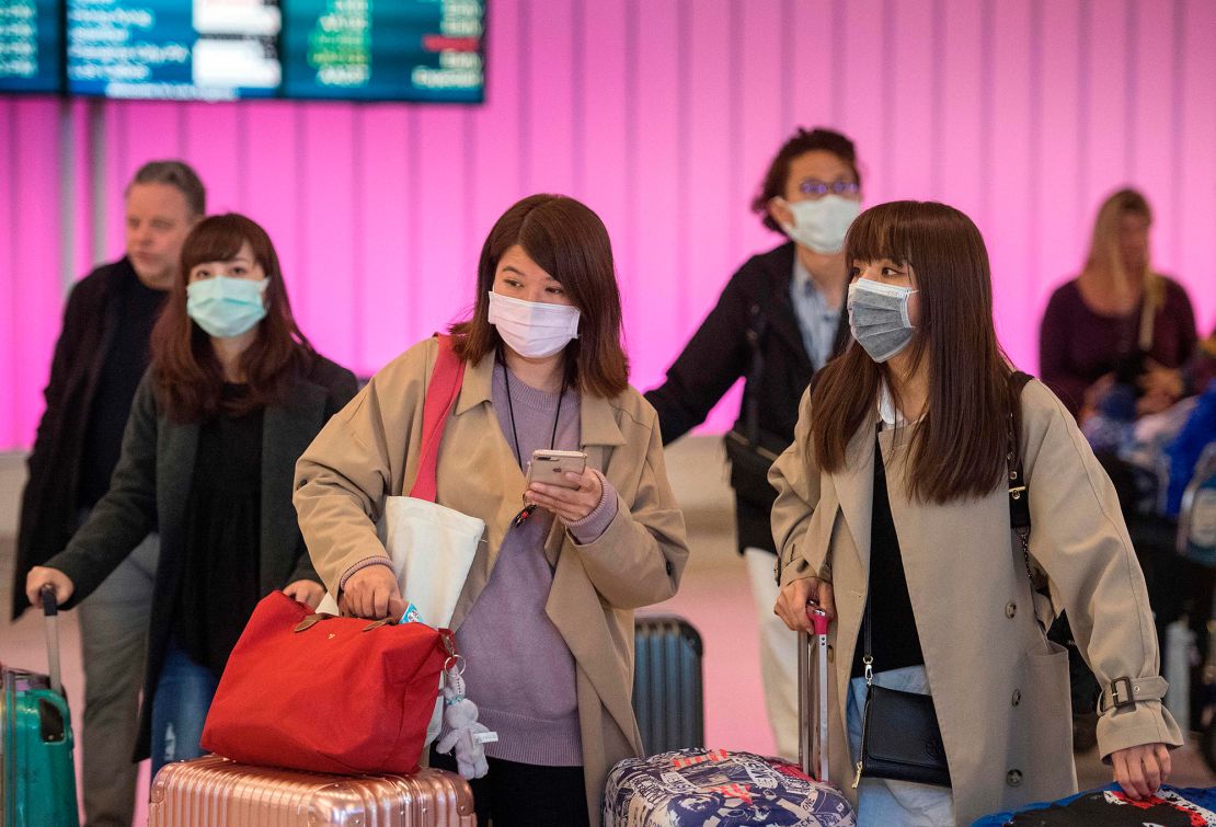 Passengers wearing protective mask as they arrive at the Los Angeles International Airport on Wednesday.