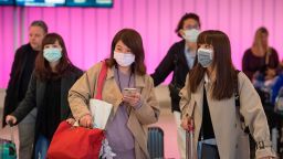 Passengers wear protective masks to protect against the spread of the Coronavirus as they arrive at the Los Angeles International Airport, California, on January 22, 2020.