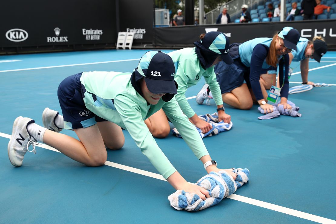 Staff clean dirt off the outside courts at Melbourne Park