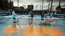 MELBOURNE, AUSTRALIA - JANUARY 23: (EDITORS NOTE: A graduated grey filter was used to create this image.) Staff are seen attempting to clean dirt off the outside courts after being caused by rainfall on day four of the 2020 Australian Open at Melbourne Park on January 23, 2020 in Melbourne, Australia. (Photo by Clive Brunskill/Getty Images)