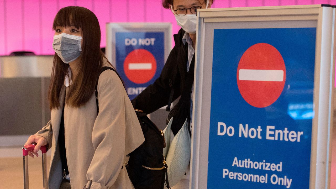 Travelers at Los Angeles International Airport wear masks as part of heightened safety measures.