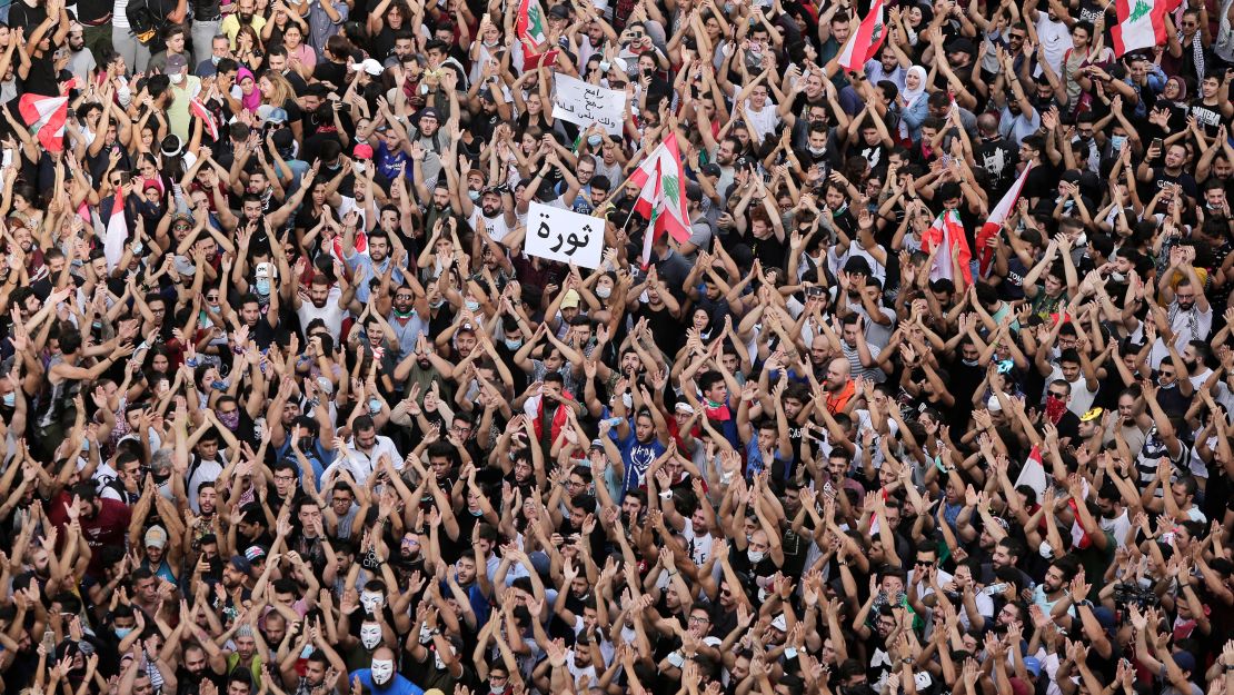 Anti-government protesters hold a sign that reads "Revolution" during protests in Beirut on October 18.