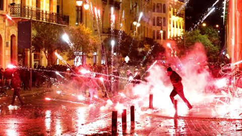 Anti-government protesters throw firecrackers at riot police during a demonstration against the new government, near Parliament Square, in Beirut, Lebanon, early Wednesday, Jan. 22, 2020.