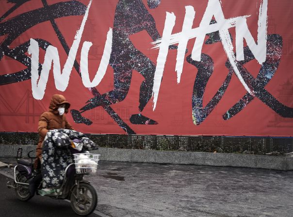 A woman rides an electric bicycle in Wuhan on January 22, 2020.