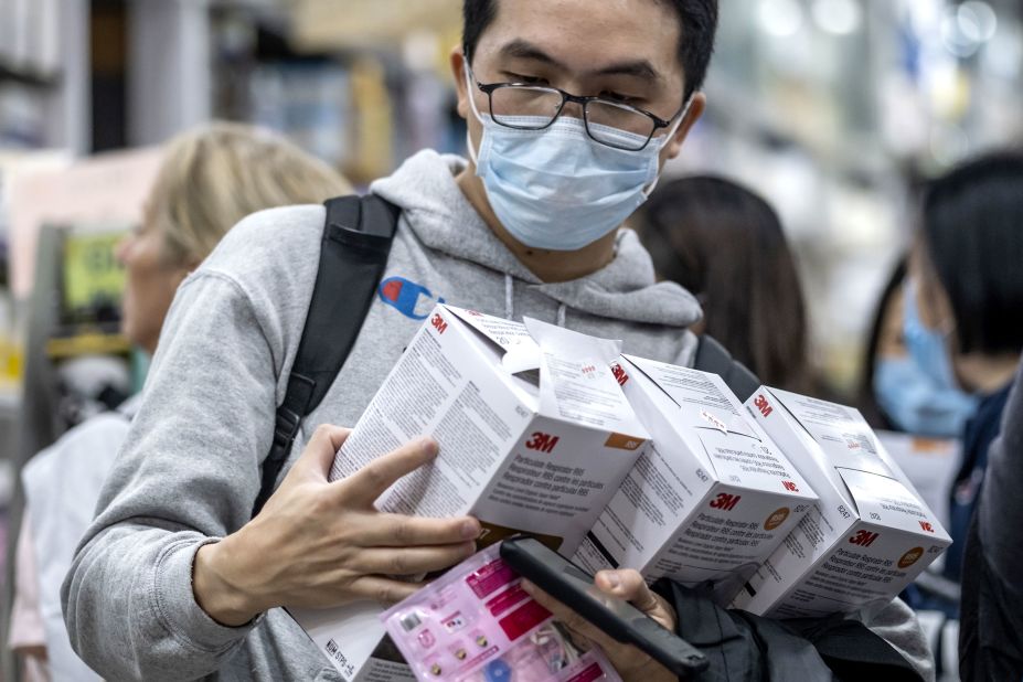 A customer holds boxes of particulate respirators at a pharmacy in Hong Kong on January 23, 2020.