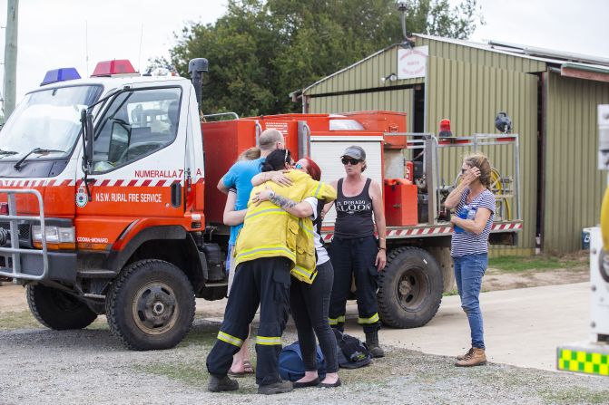 People embrace near the scene of a <a href="index.php?page=&url=https%3A%2F%2Fwww.cnn.com%2F2020%2F01%2F23%2Faustralia%2Faustralia-firefighter-crash-intl-hnk%2Findex.html" target="_blank">water tanker plane crash</a> in Cooma, Australia, on Thursday, January 23. Three American crew members died in the crash.