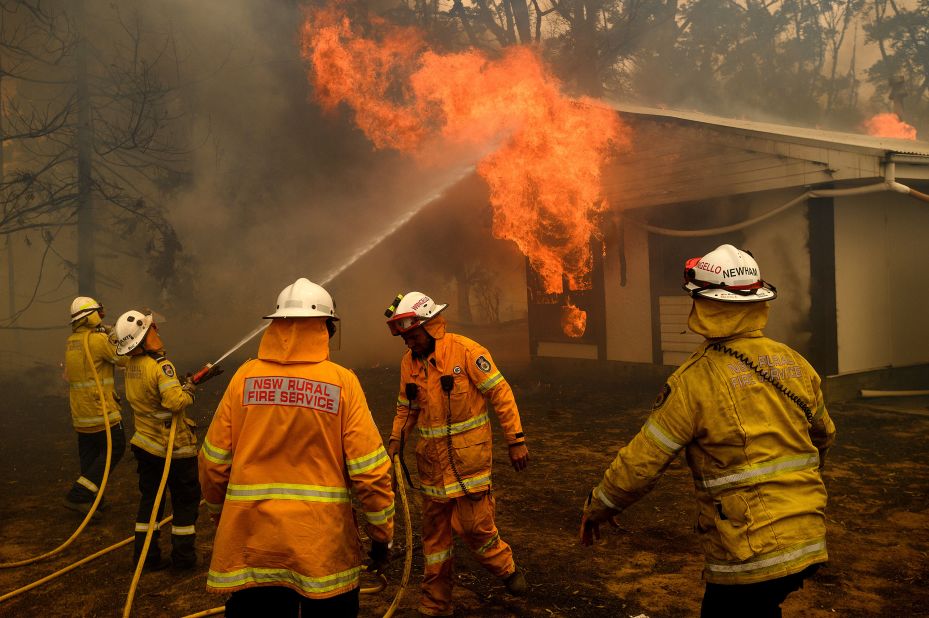 Firefighters battle the Morton Fire as it burns a home near Bundanoon, Australia, on January 23.