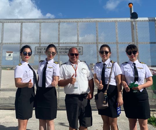 <strong>Aviation cosplay: </strong>Pilot George Haines poses with tourists from China who dressed up as pilots for a Star Marianas Air flight from Saipan International Airport. 