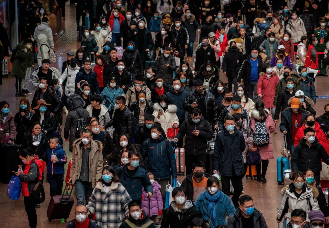 Chinese passengers, most wearing masks, prepare to board trains in Beijing on Thursday, January 23, before the annual Lunar New Year Spring Festival.