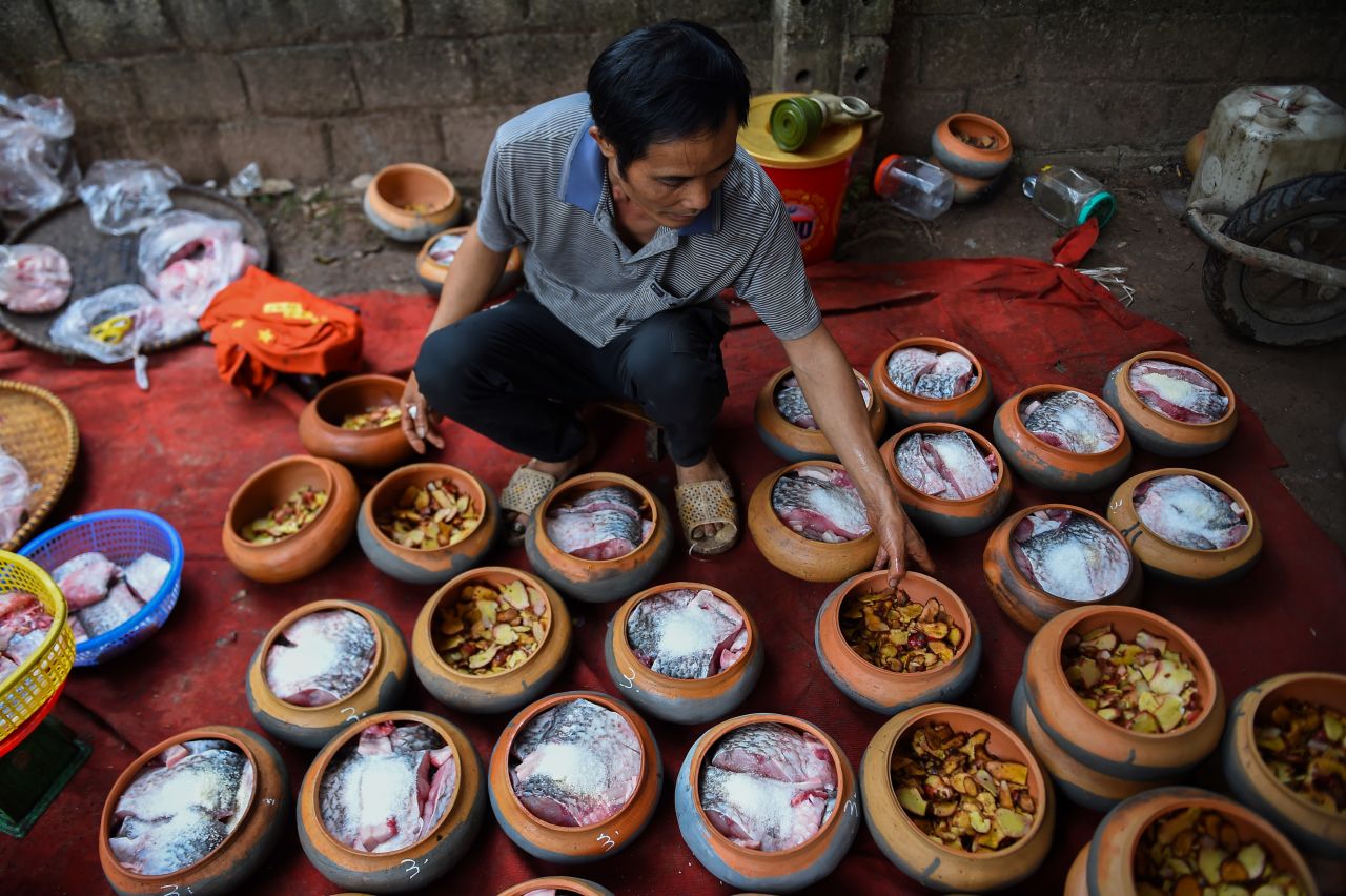 A man prepares carp in clay pots to cook in Ha Nam province on Tuesday, January 21. The braised fish is a popular delicacy for the Lunar New Year, or Tet season, in northern Vietnam.