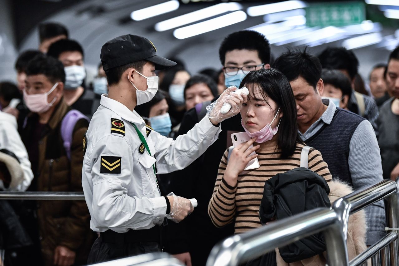 People wear protective masks and go through a checkpoint in Guangzhou, China, on Wednesday, January 22. <a href="https://www.cnn.com/2020/01/23/world/gallery/wuhan-coronavirus-outbreak/index.html" target="_blank">The deadly Wuhan coronavirus</a> was first reported in late December in Wuhan, a major city in central China. Since then, sick travelers from Wuhan have infected people in China and other countries, including the United States.
